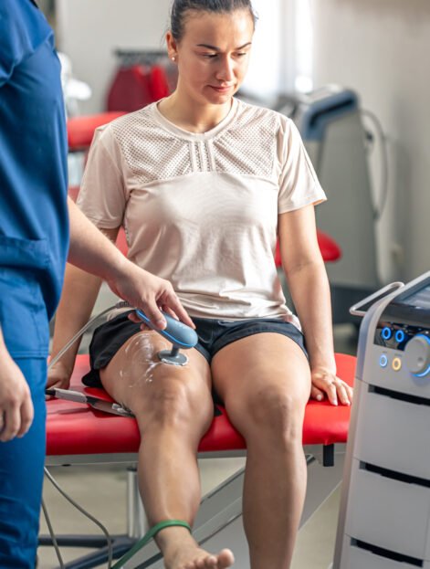 Doctor using machine to treat the knee joints of a patient, T-CaRe technology, resistive and Capacitive therapy.
