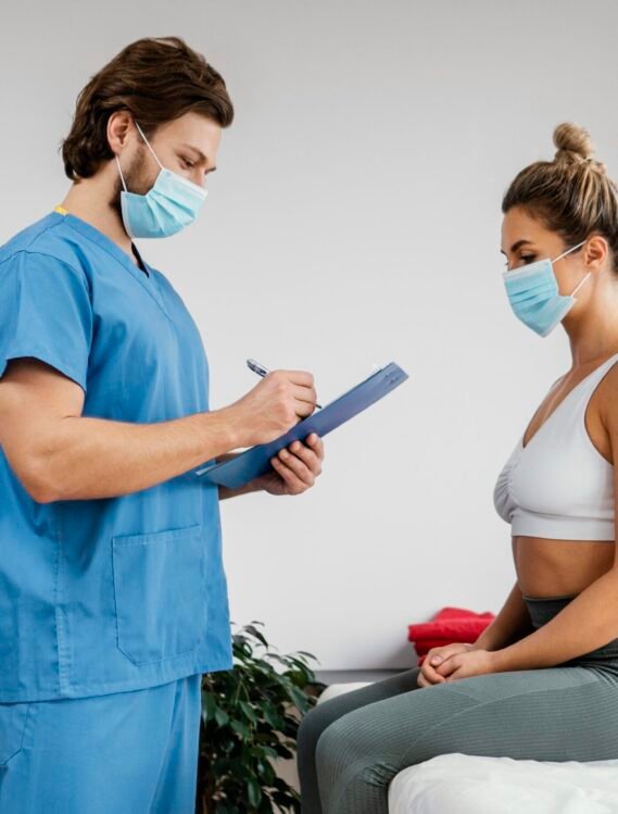 side-male-osteopathic-therapist-with-medical-mask-female-patient-office-signing-clipboard.jpg